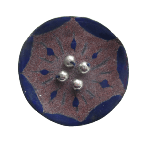 Smaltovaná brož fialová květina. Brož kulatého tvaru s mírně zvednutými okraji s kresbou fialovomodré květiny na ručně opracovaném nerezovém plíšku. Střed květu tvoří korálky stříbrné barvy. Zespodu je podlepená fialovou plstí. Špendlík stříbrné barvy je připevněný pomocí plastu.