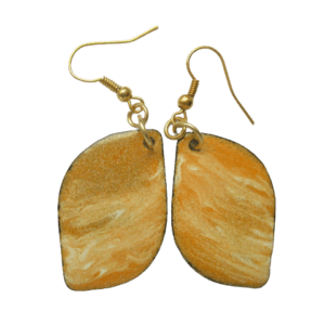 Smaltované náušnice tvaru listu s jemnou oranžovobéžovou kresbou na ručně opracovaných nerezových plíšcích. Jsou zavěšené za vrchol na háčcích zlaté barvy.