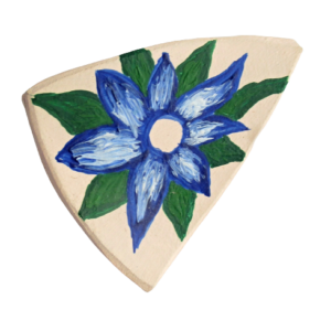 Brož z kůže modrá květina. Brož ve tvaru asymetrického trojúhelníku se stylizovanou kresbou květiny vystřižená z kůže a malovaná modrou, bílou, béžovou a zelenou akrylovou barvou. Ze spodní strany je pomocí průhledného plastu připevněný spínací špendlík stříbrné barvy.