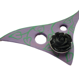 Fialová brož. Brož ve tvaru vykrojeného trojúhelníku s kulatými otvory vystřižená z kůže a malovaná fialovou akrylovou barvou. Na fialovém podkladu jsou zelenou barvou namalované lístky. Ze spodní strany je podlepená fialovou plstí se spínacím špendlíkem zlaté barvy.