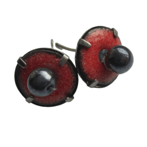 Růžové smaltované kulaté náušnice na ručně opracovaných nerezových plíšcích mechanicky uchycené v puzetkách antracitové barvy, ve středu doplněné černými korálky.