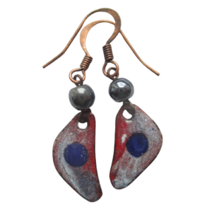 Červenomodré smaltované náušnice. Náušnice ve tvaru zaobleného trojúhelníku s modrým puntíkem na fialovočerveném podkladu na ručně opracovaném nerezovém plíšku, doplněné korálky. Jsou zavěšené za jeden vrchol na háčcích měděné barvy.