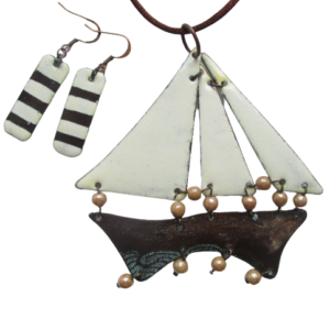 Smaltovaná námořnická souprava. Souprava náhrdelníku a náušnic. Náhrdelník je složený ze čtyř dílů ve tvaru trupu lodi a tří plachet a náušnice ve tvaru obdélníku na ručně opracovaných nerezových plíšcích. Plachty jsou v bílé barvy, trup lodi v hnědé a náušnice v obou. Komponenty jsou v mosazné barvě.
