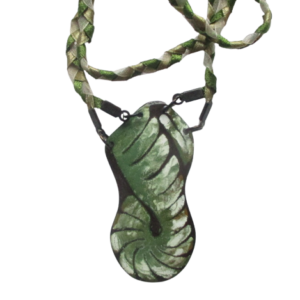 Splétaný smaltovaný přívěsek. Přívěsek asymetrického tvaru s motivem zelenobílého spleteného provázku na ručně opracovaném nerezovém plíšku. Motiv spleteného provazu pokračuje copánkem z drobných stužek až k zapínání. Komponenty jsou v černé barvě.