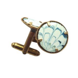 Světlé smaltované manžetové knoflíky. Hodí se k obleku v tmavě modré až tyrkysové barvě. Ladí s jehlicí do klopy se stejnou kresbou.