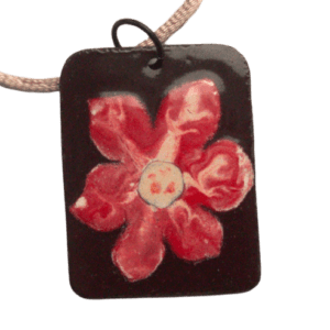Smaltovaný přívěsek s červenou květinou. Velký přívěsek je navržený k zavěšení na delší šňůrce. Vynikne na šatech nebo roláku. Dodávám je se saténovou šňůrku ladící barvy. Doplňte jej náušnice, broží nebo prstenem ze stejné kolekce.