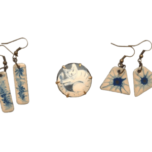 Smaltovaná souprava s modrou kočkou. Jemná kombinace barev se hodí k formálnímu či minimalistickému stylu. Vyberte si k broži ladící náušnice.