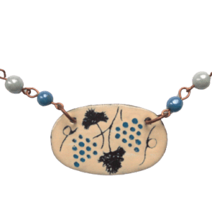 Smaltovaný přívěsek s modrými vinnými hrozny z kolekce inspirované krojem mělnického folklórního souboru. Je navržený k nošení na kratší šňůrce. Sluší podzimnímu typu. Dolaďte jej náušnicemi nebo brož ze stejné kolekce.