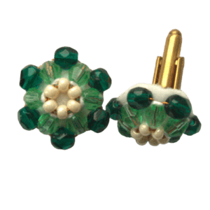 Zelenkavé korálkové manžetové knoflíčky. Hodí se k čistě bílé nebo zelené košili. Doplňte je jehlicí do klopy zve stejných barvách. S vaším dámským doprovodem se můžete sladit pomocí šperků ze stejné soupravy.