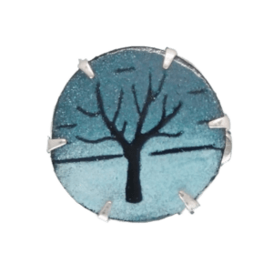 Smaltovaná zimní brož se stromem. Je ideálním doplňkem pro minimalistické outfity. Její jemný design a chladné barvy evokují zimní atmosféru, zatímco motiv stromu přináší přírodní krásu do vašeho stylu. Perfektní volba pro ty, kteří preferují jednoduchost, ale chtějí do svého vzhledu přidat elegantní akcent. Tato brož se snadno kombinuje s různými minimalistickými kousky a dodá vašemu outfitu sofistikovanost a jemný, ale výrazný detail. vyberte si k náušnice se stejnou kresbou.