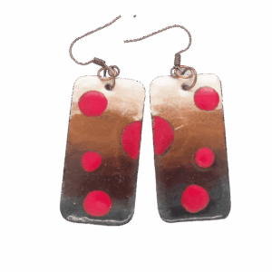 Obdélníkové smaltované náušnice s červenými puntíky v přírodních odstínech, zavěšené na měděných háčcích, ručně zpracované.