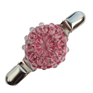 Růžová korálková oděvní spona z křišťálových korálků s květinovým knoflíkem a sytě fialovým podšitím.