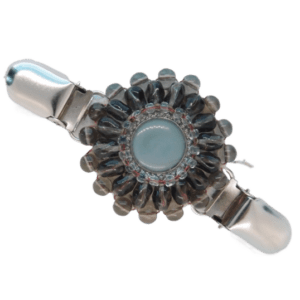 Šedá korálková oděvní spona s výrazným knoflíkem uprostřed, vhodná k minimalistickým outfitům.