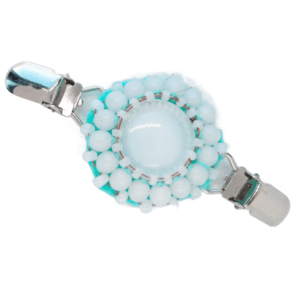 Bílá korálková oděvní spona s tyrkysovým podšitím v čistém, minimalistickém stylu.